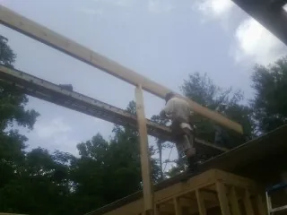 Carpenter setting a ridge beam over a new addition frame — Ice Dam Removal by Roofing Brothers in Rimrock